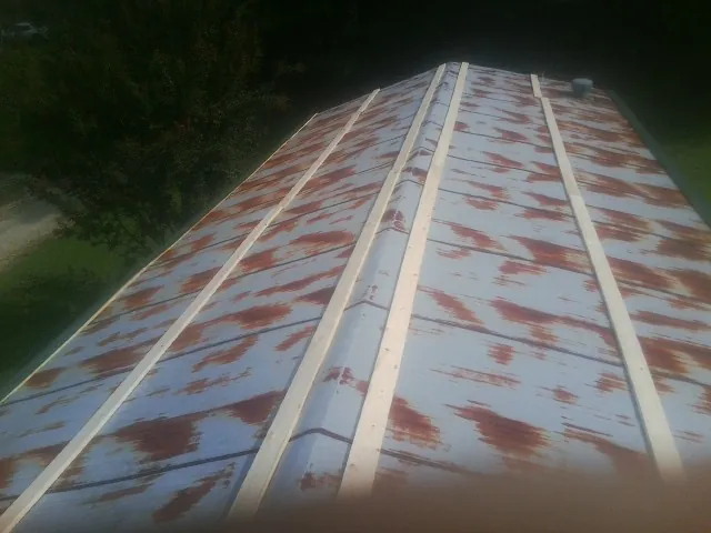 Rusted metal roof panels with new wood purlins before replacement — Storm Damage Roof Repair in Cato by Roofing Brothers