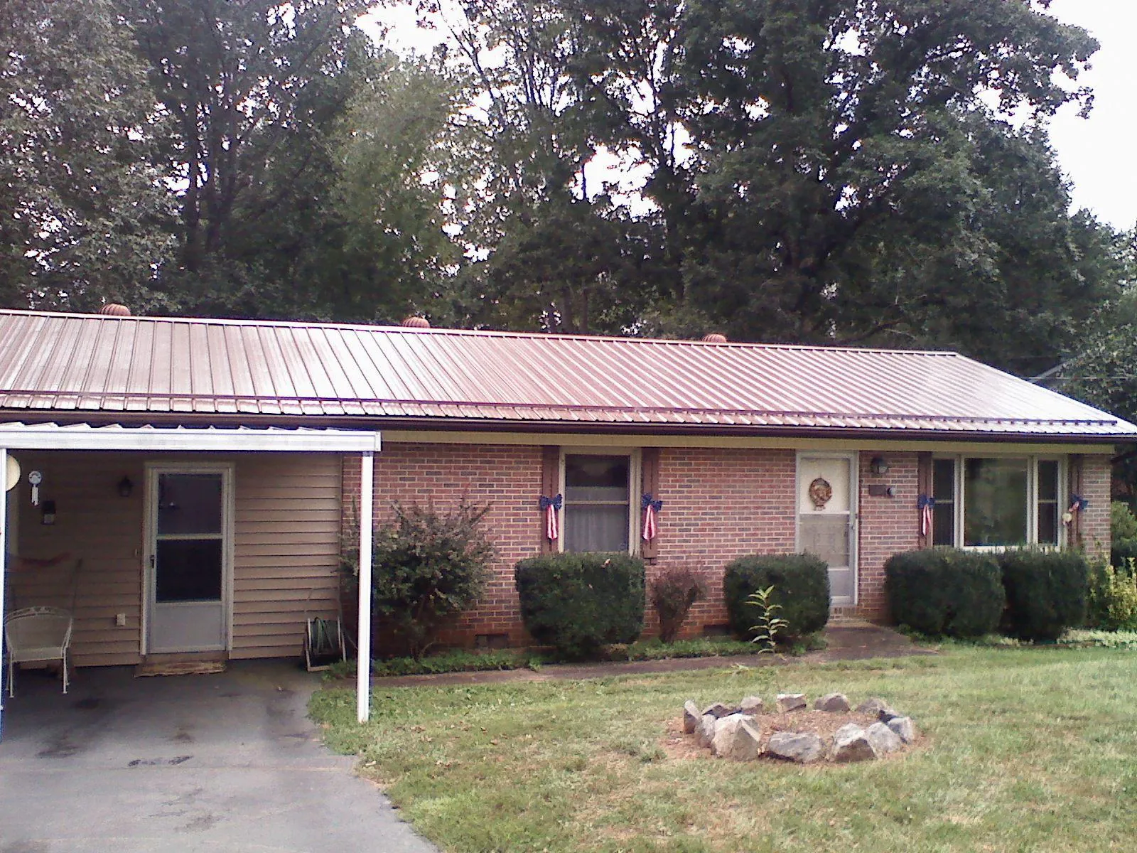 Bronze metal roof and carport on a brick ranch home — Roof Repair work by our crew in Cato