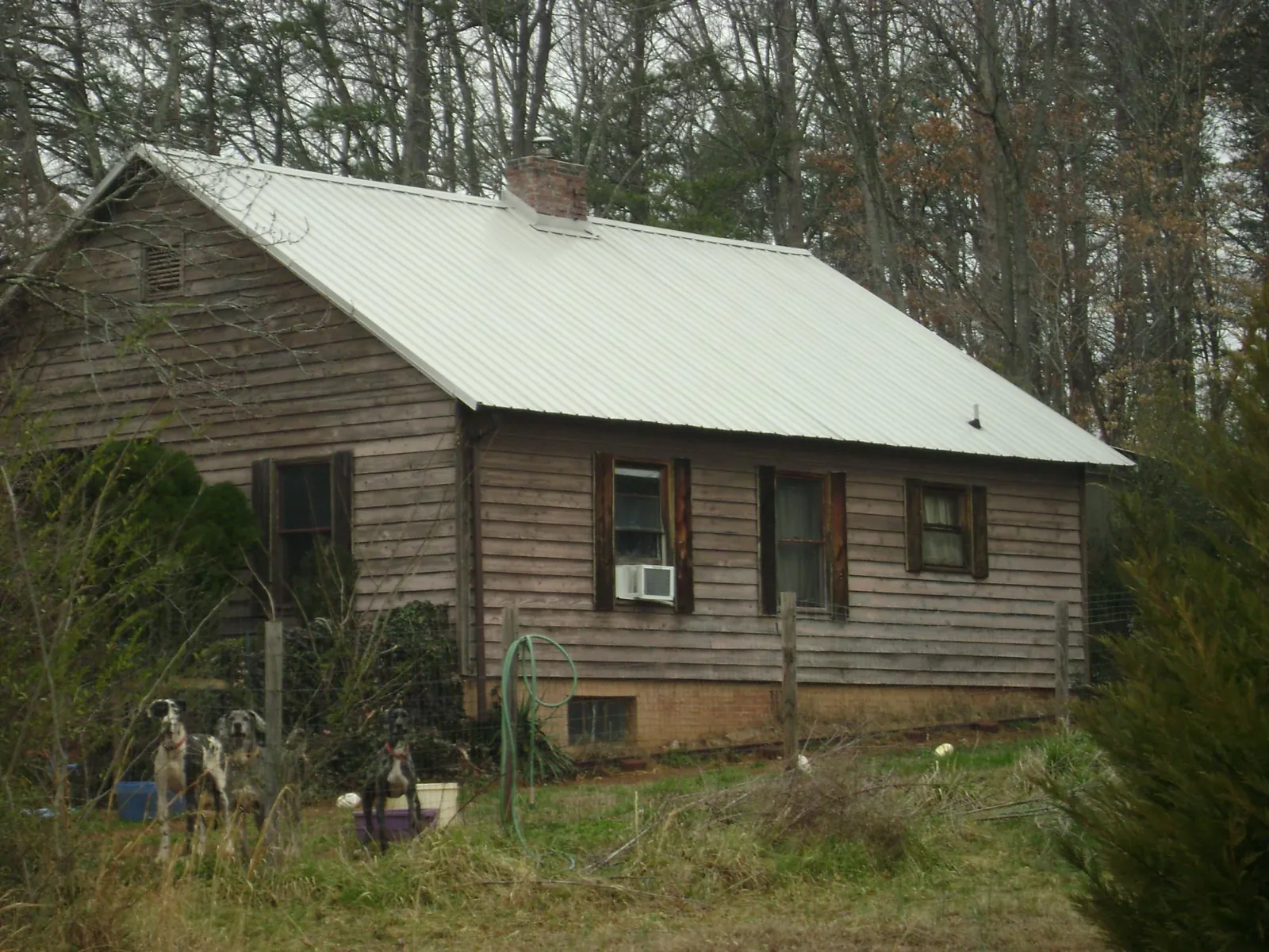 White metal roof on an old wood sided farmhouse, from a Metal Roof Installation job in Cato